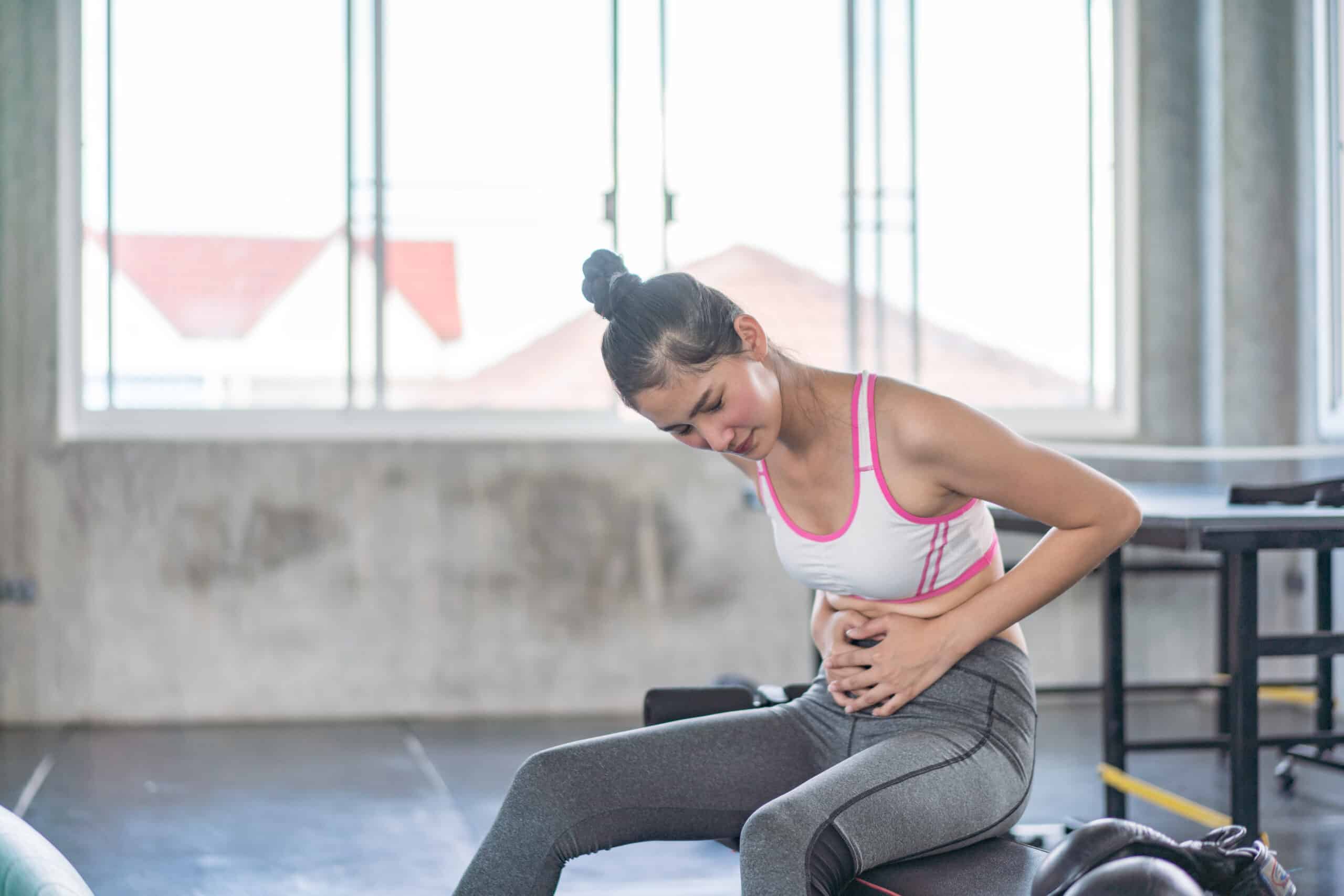 Young fit sporty woman with painful face expression