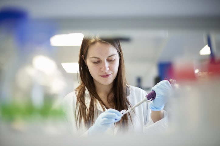 Female science student pipetting in laboratory